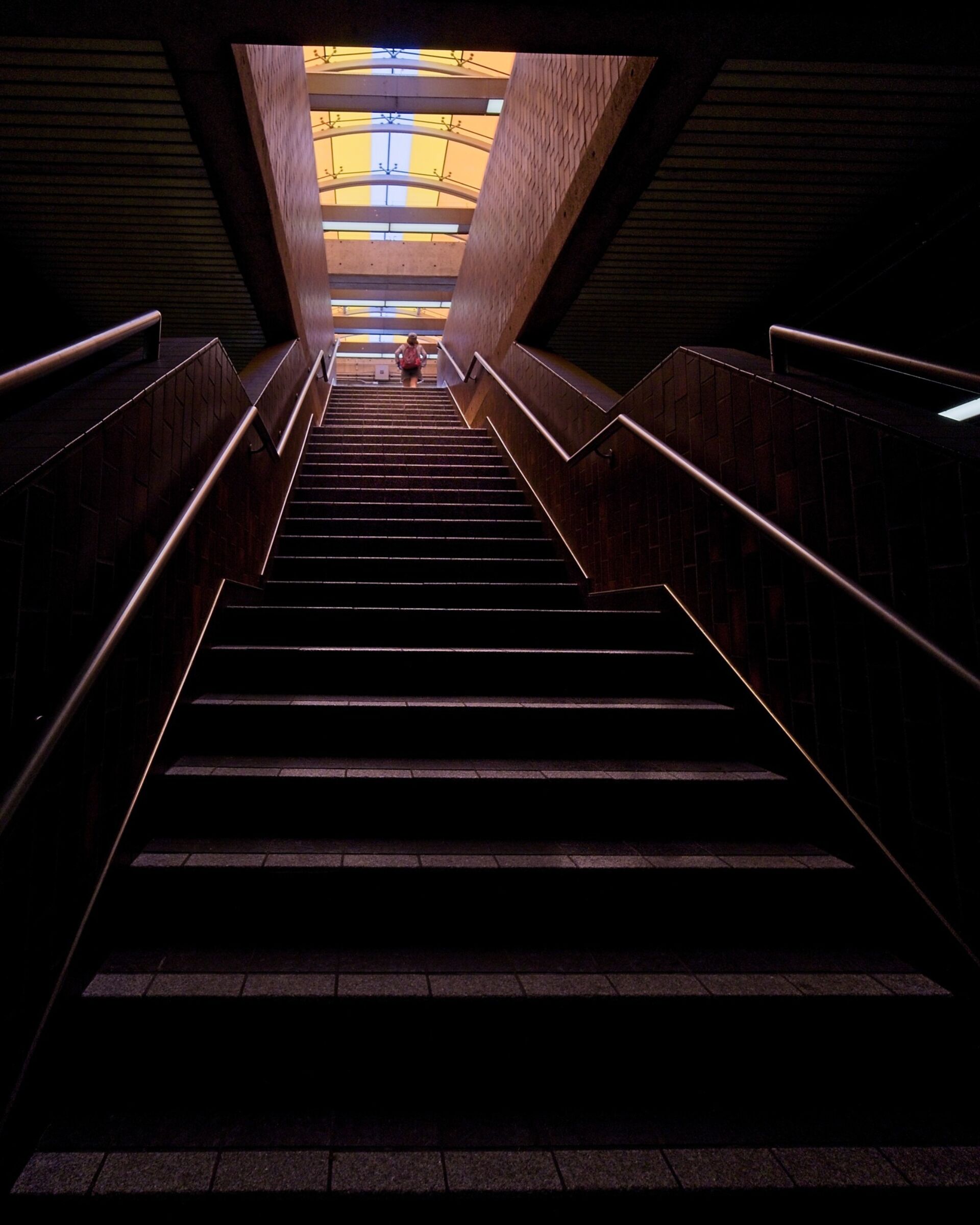 Stairs to concourse level lit by skylight.
