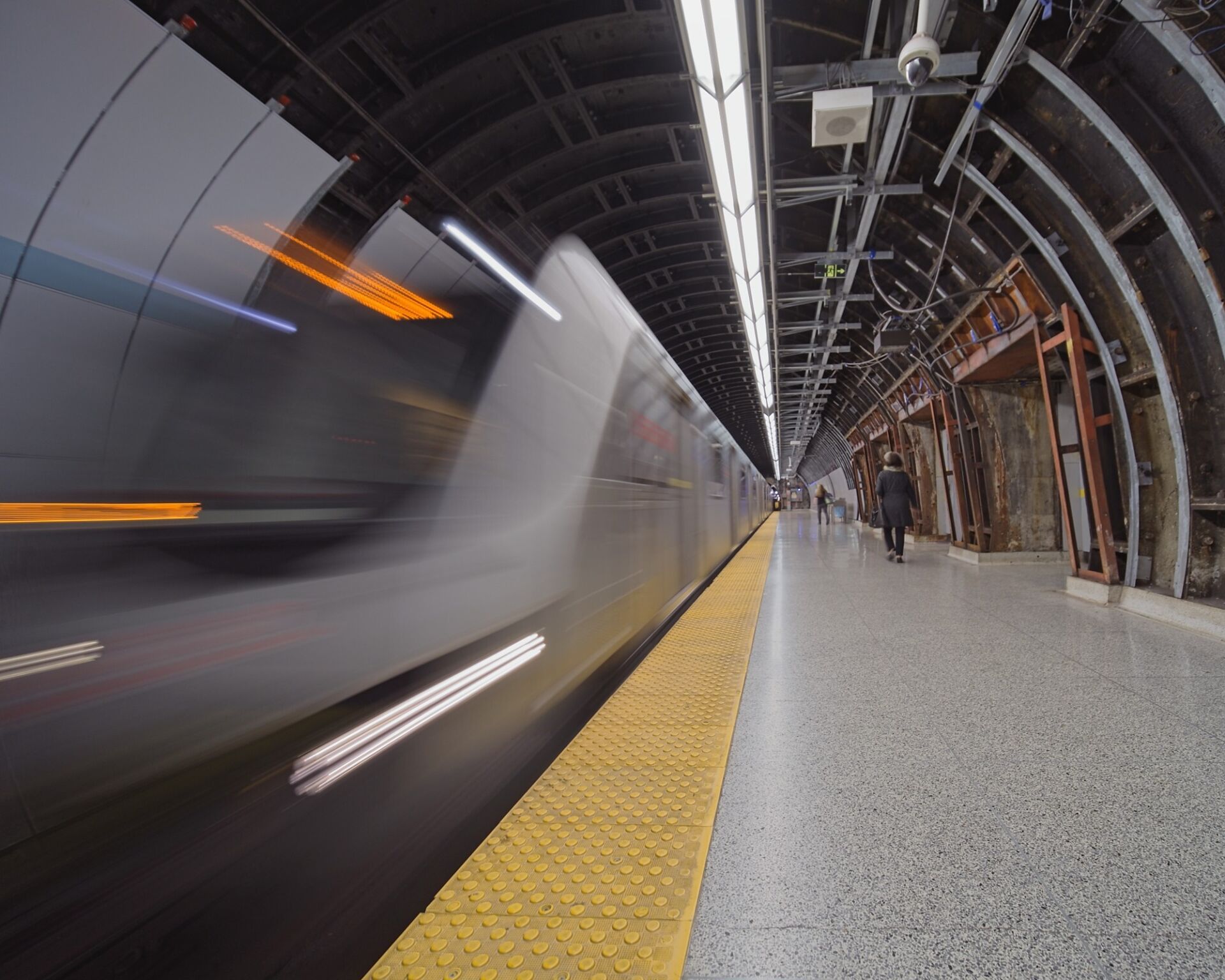 Train arriving at track level with the gritty unfinished ceiling and walls.