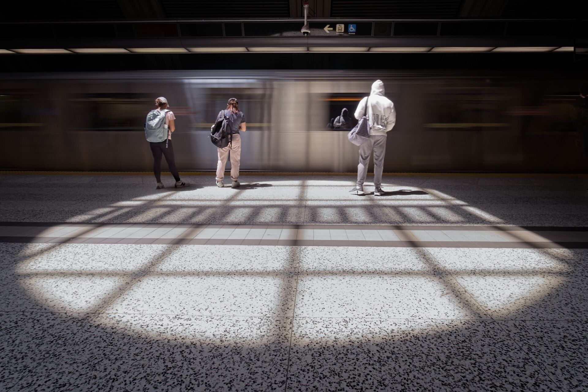 Skylight spotlights passengers and arriving train.