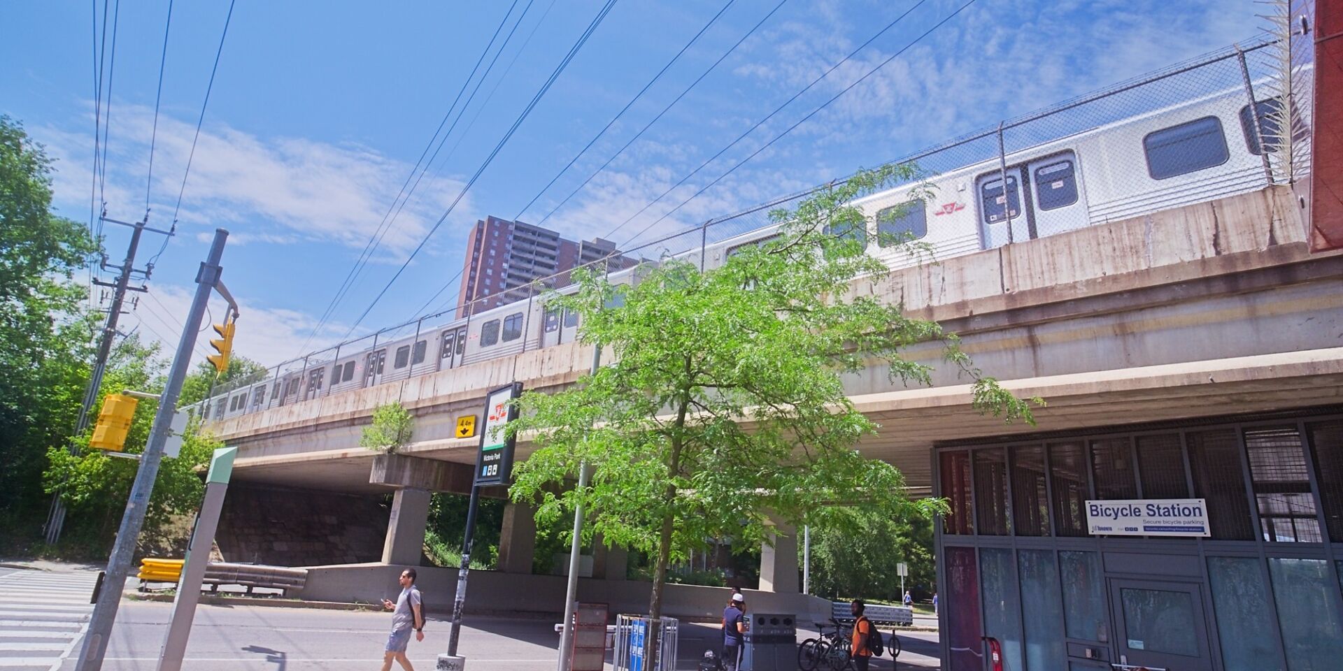 Train running on top of the pedestrian overpass across Victoria Park Avenue.