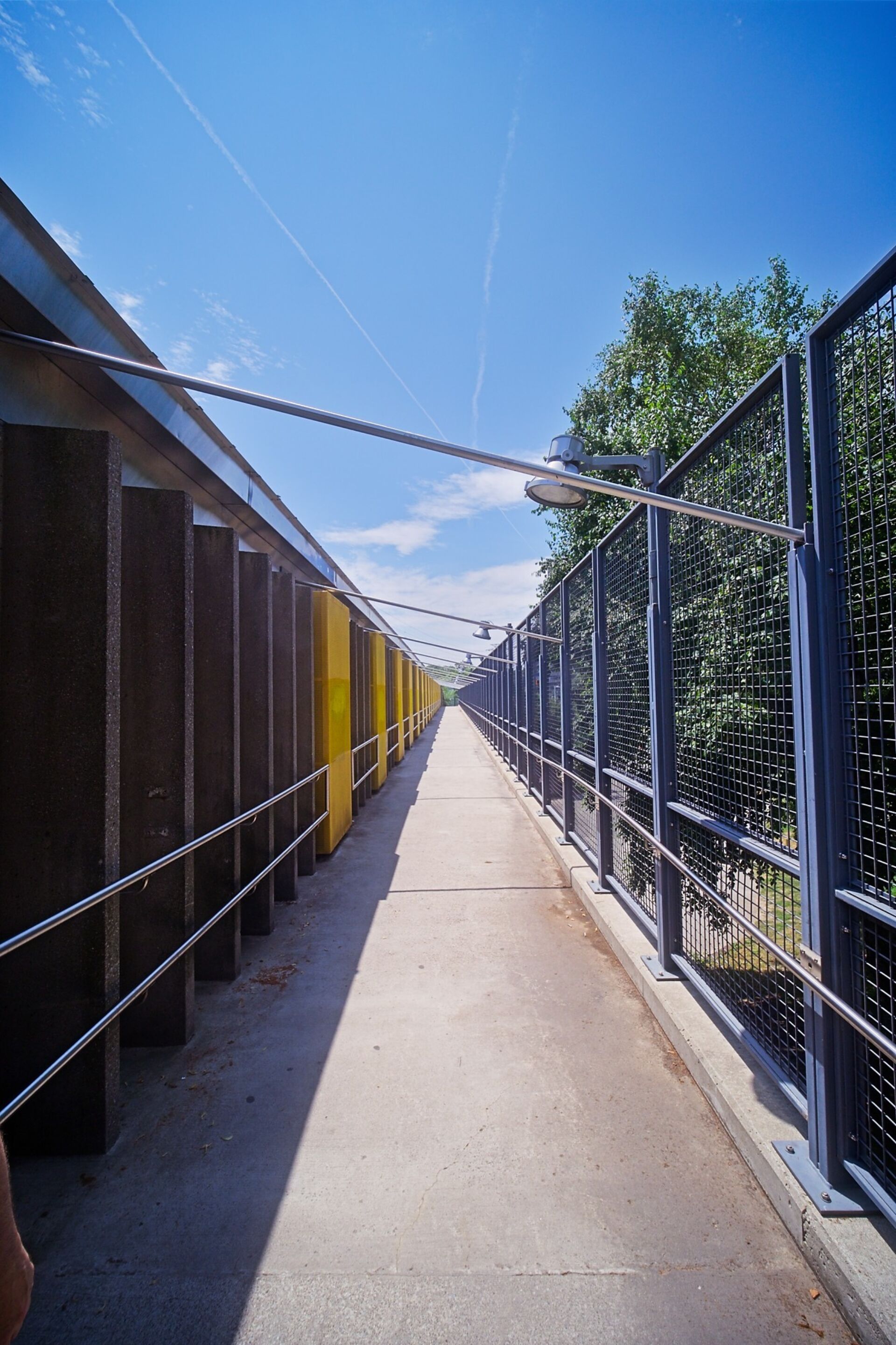 Walkway from rear entrance to front entrance with protective fencing for stray golf balls from the golf course next door.