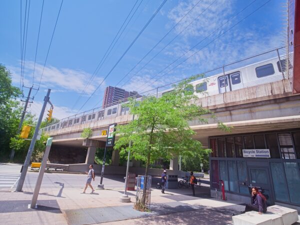 Train running on top of the pedestrian overpass across Victoria Park Avenue.